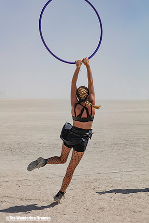Woman swinging on a hoop at Burning Man in Black Rock City Nevada