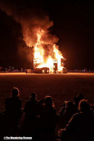The Folly art project at Burning Man in Black Rock City Nevada has a crowd watch it burn