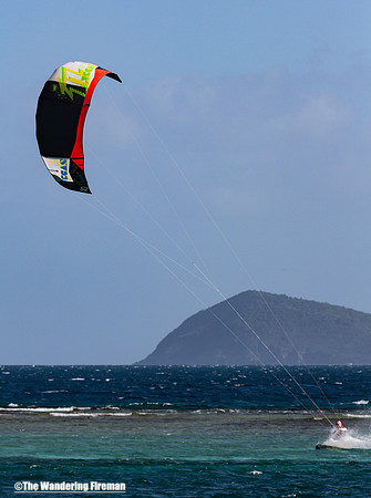 Kite surfer racing the waves