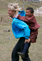 Sue giving a child in Bhutan a piggyback ride