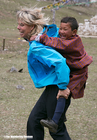 Sue giving a child in Bhutan a piggyback ride