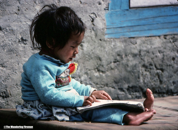 Young child reading a book in Nepal