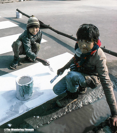 Two boys paint the roadway in Kathmandu Nepal