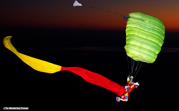 Tube skydiver under canopy at night