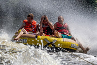 Three friends enjoy a tube ride behind a boat