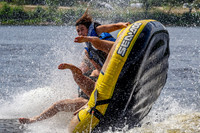 Girls dumping a tube being pulled behind a boat