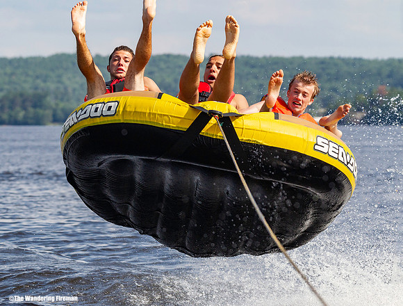 Three teens catch massive air while tubing behind a boat