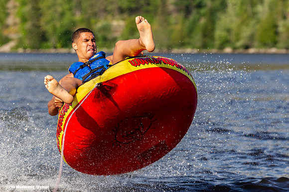 Grimacing while riding a tube behind a boat