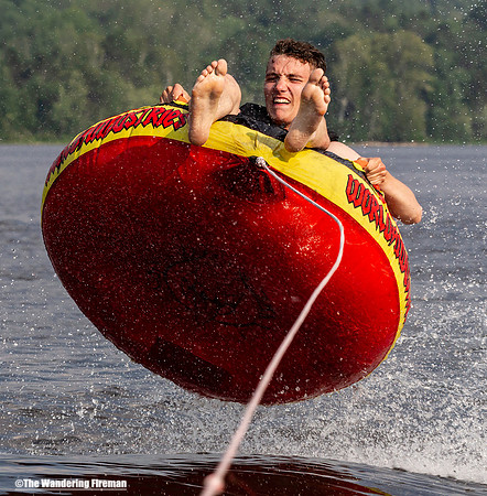 Solo teen rides a tube behind a boat