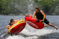 Two gladiators battle it ot on tubes behind a boat