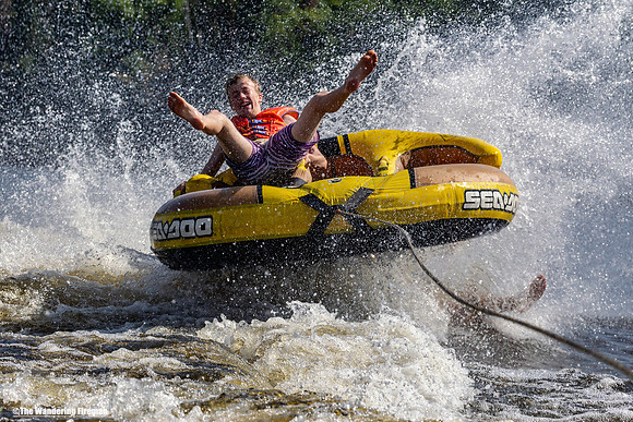 Huge spray from tubing fun behind a boat