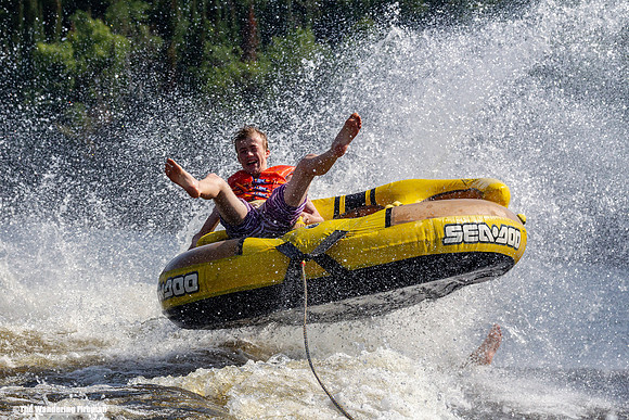 Tubing spray and fun behind a boat
