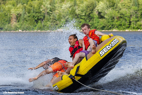 Teen falls out the side of a tube being pulled behind a boat