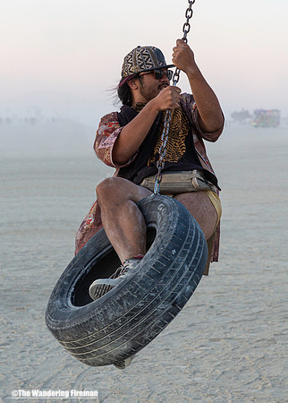 Swinging on a tire at Burning Man