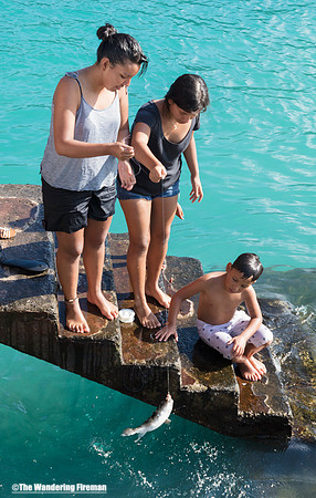 Kids fishing off a pier in Puerto Ayoro
