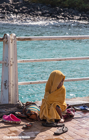 Young girl sitting with her puppy on a pier in Puerto Ayoro
