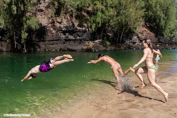 Kids jumping into a river in Kauai Hawaii