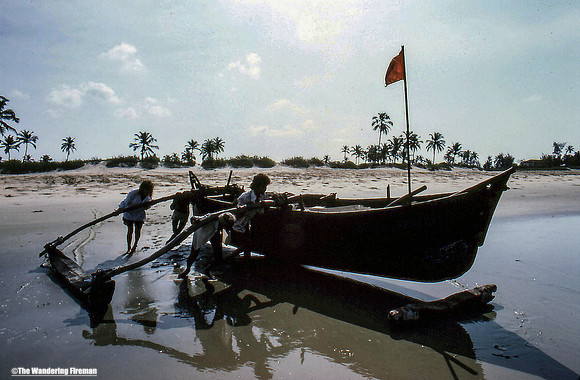 Pushing out a boat into the ocean in Goa India