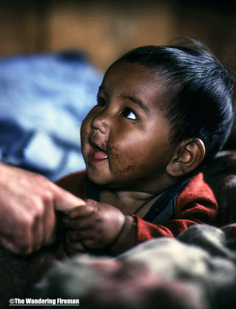Very cute baby pulling mothers finger in Nepal