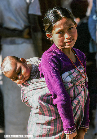 Young girl holding her baby brother in Nepal