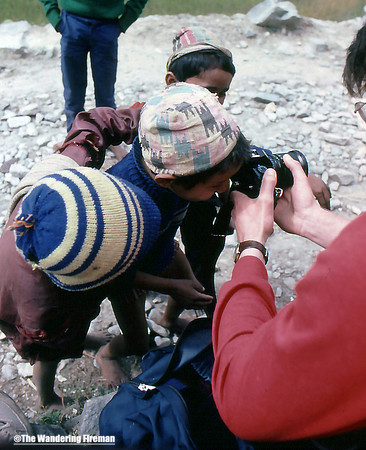 Young Nepalese children look through a camera