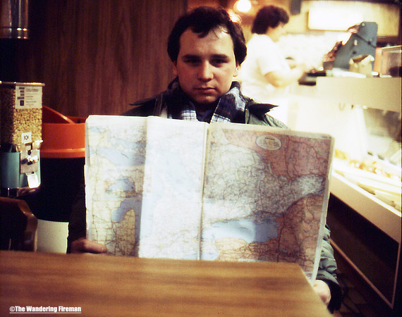 Me reading a road atlas at breakfast on our road trip to California