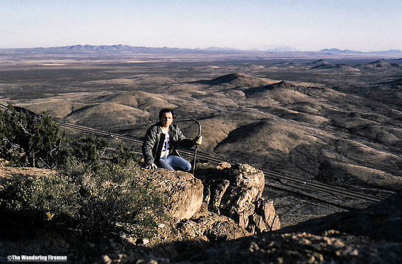 Me kneeling on a small mountain hill in New Mexico on our road trip to California