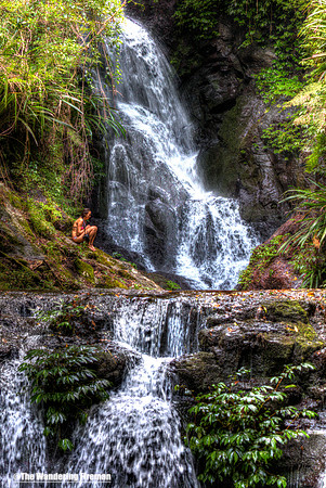 Girl resting in front of waterfall in Lamington National Park