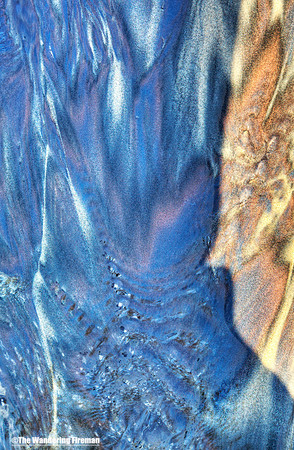 Graphic image of water rivulets on a sandy beach