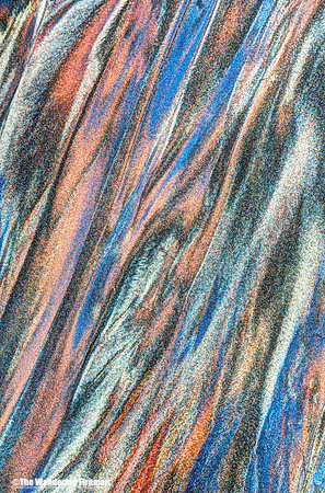 Graphic image of water rivulets through a sandy beach