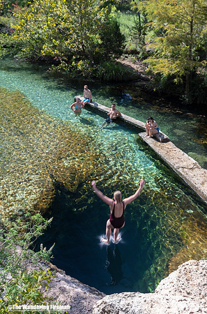 Jumping into Jacob's Well fresh water spring in Texas
