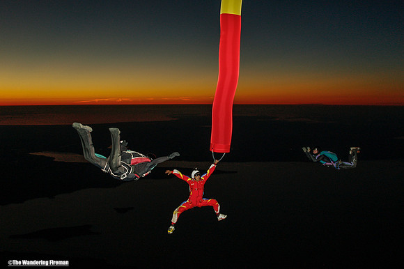 Skydiver with a tube being chased by other skydivers