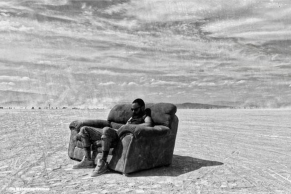 Man sitting on a chair way out on the playa of Burning Man